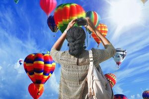 woman taking photos of hot air balloon rides